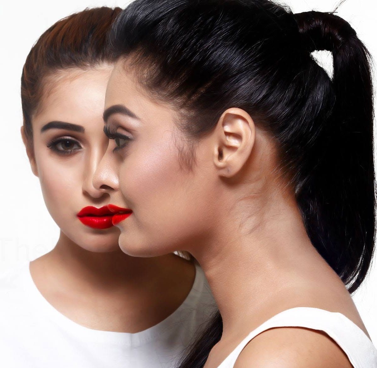 Two women in profile, one in soft focus behind the other, both wearing bold red lipstick