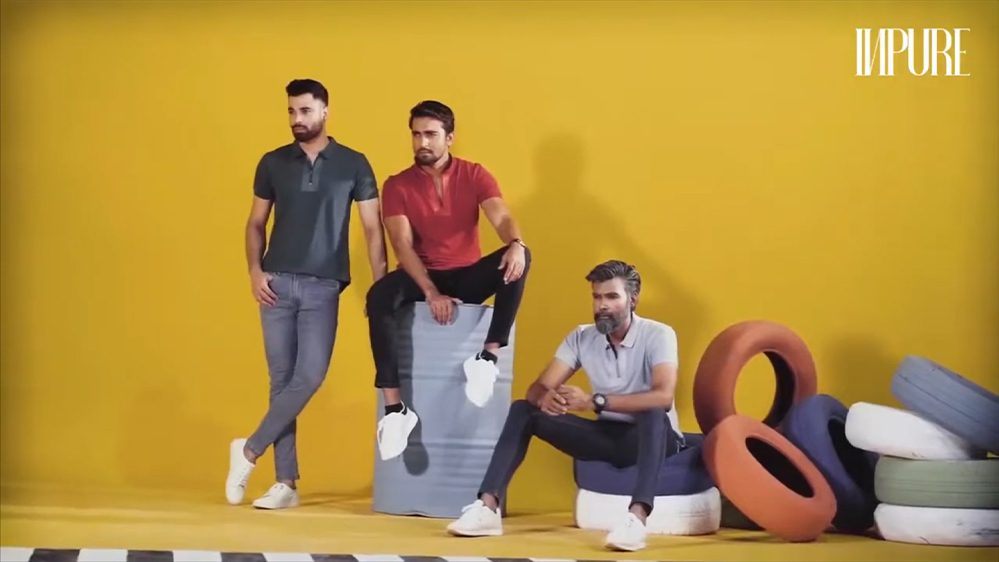 Three men in casual shirts posed against a yellow wall in an Inpure fashion shoot